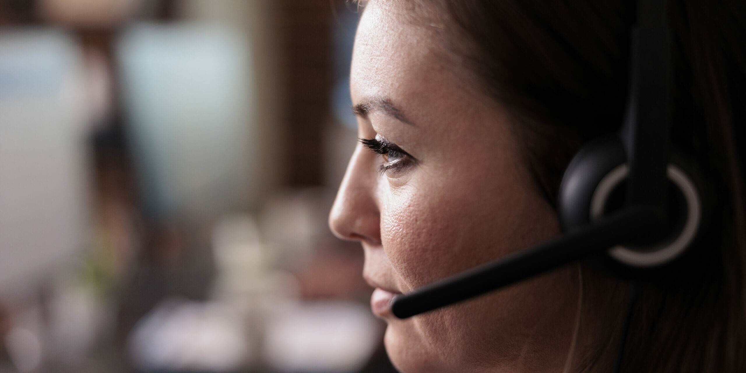 Female receptionist wearing headphones to work at call center